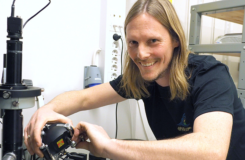 A man working with an instrument and smiling