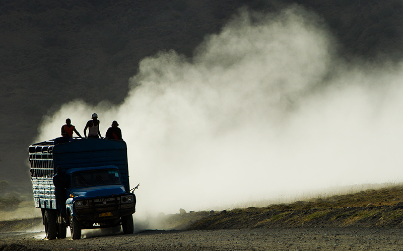A car driving on a dusty road. Photo
