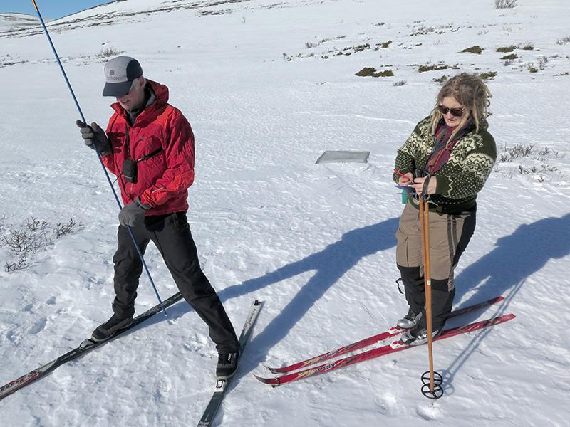 Two researchers in the snow with skis on. Photo
