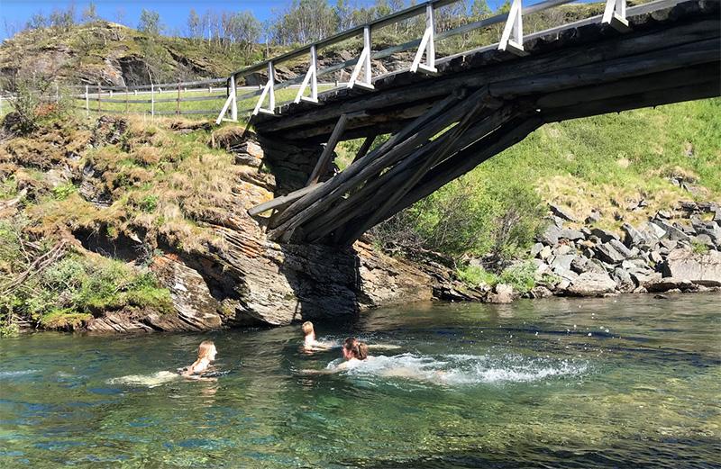 Three researchers swimming under a bridge. Photo