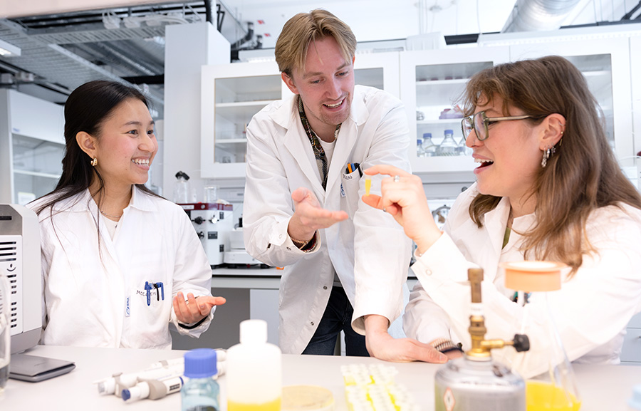 Three students working together with an experiment in a laboratory
