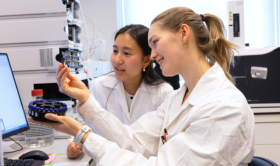 Two students examining a sample in a laboratory.