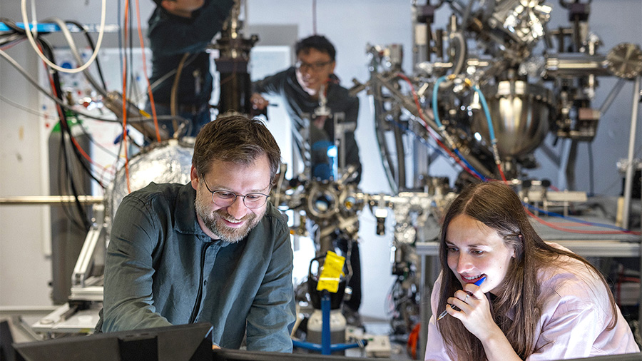 Researchers discussing in front of a computer in a laboratory
