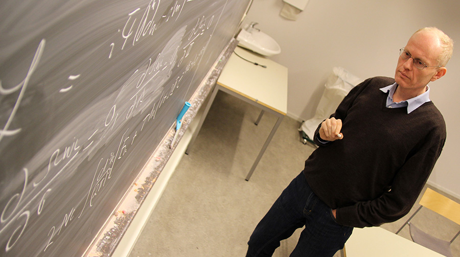 Professor Jens. O. Andersen working on equations on the blackboard. Photo