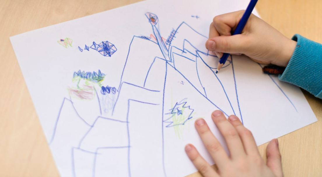 Picture of a child drawing on a paper