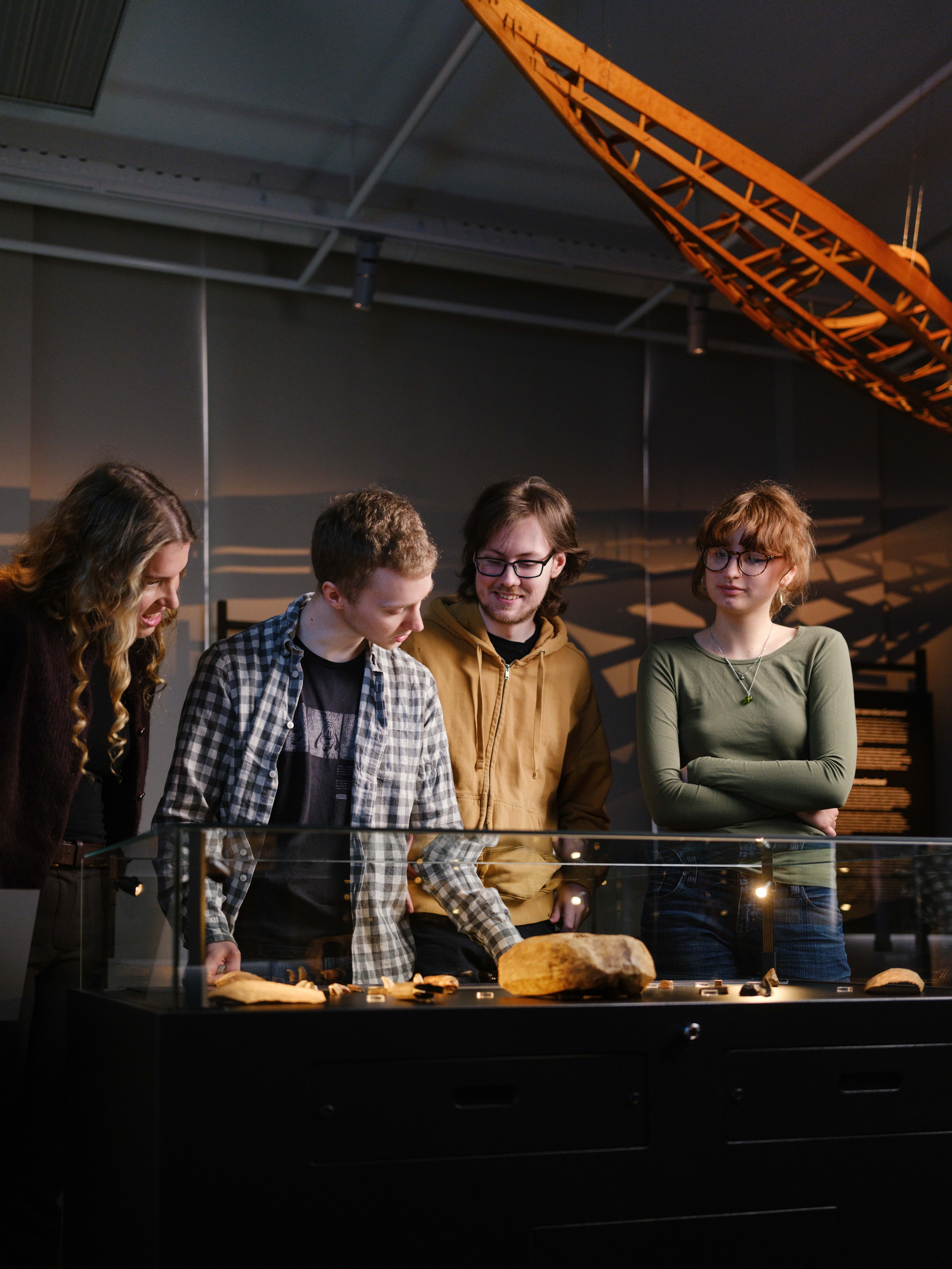  61 Group of young people looking at objects in a glass case.