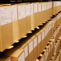 Photo of private archives in boxes shelved in the repository