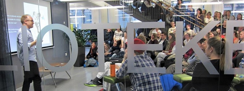 Photo of speaker and  a large audience during an event in the library