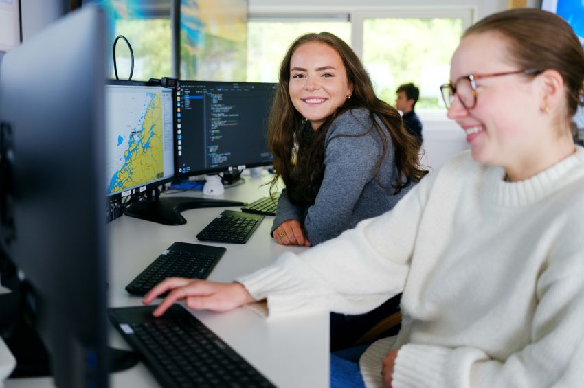 Two students working on their studies using a computer