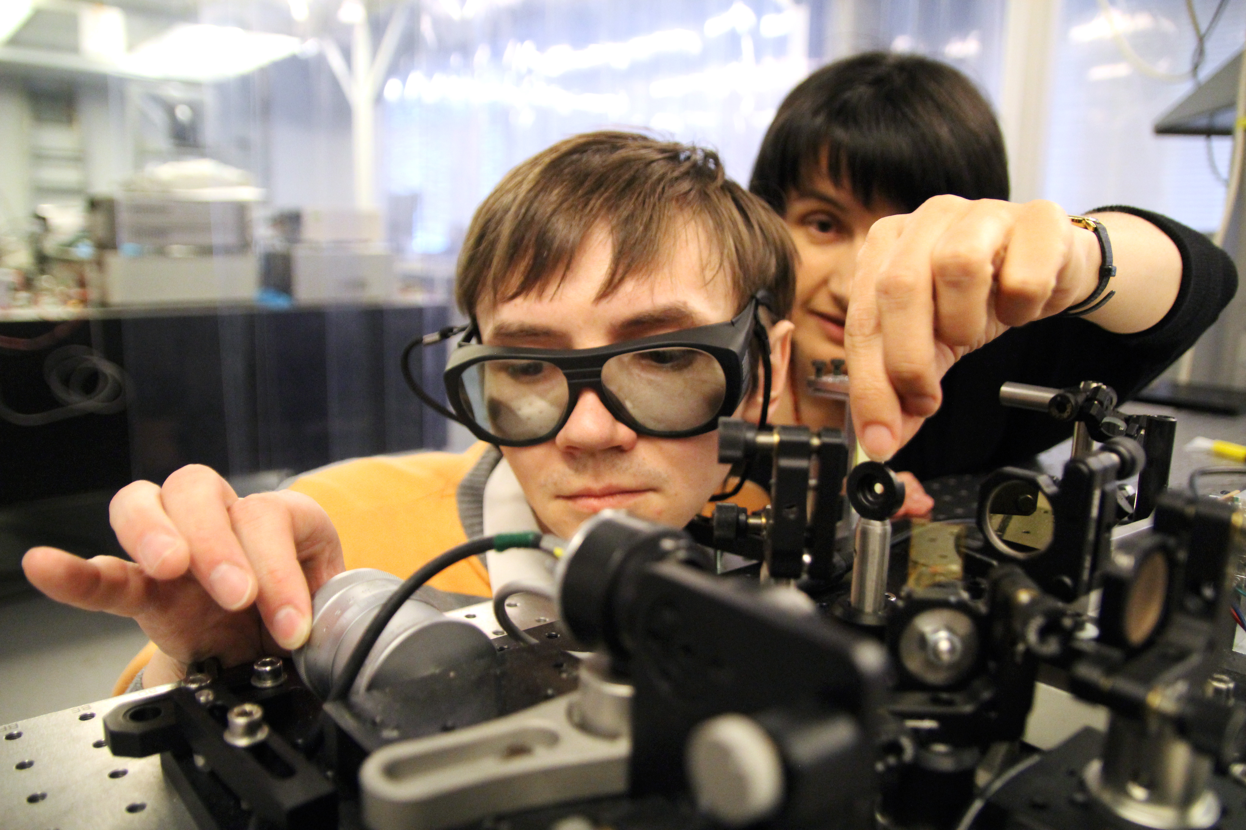 Student in lab with supervisor behind. Photo