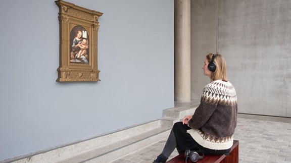 Woman studying a painting in a gallery