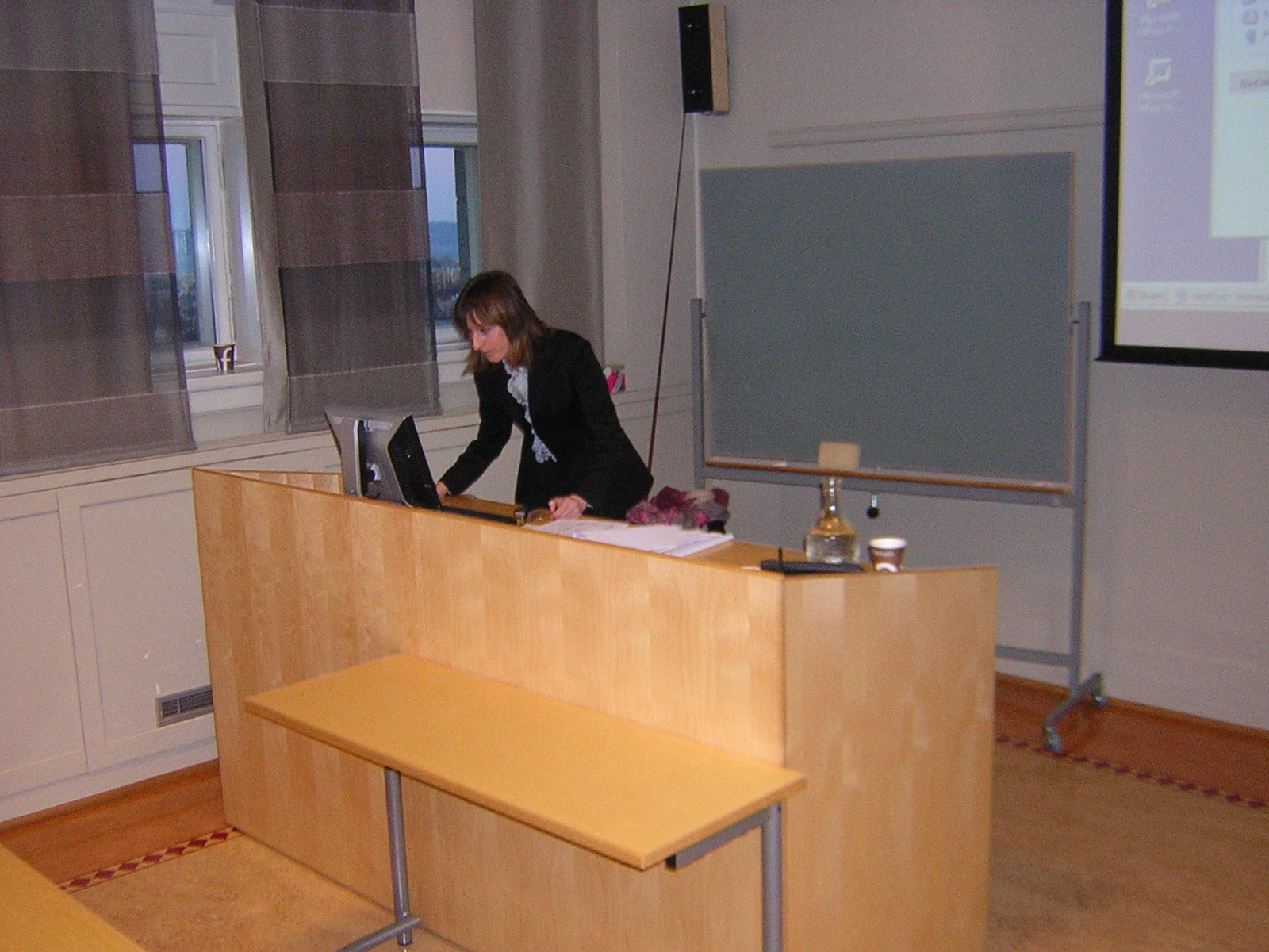 Student looking at a computer standing behind a desk. Photo.