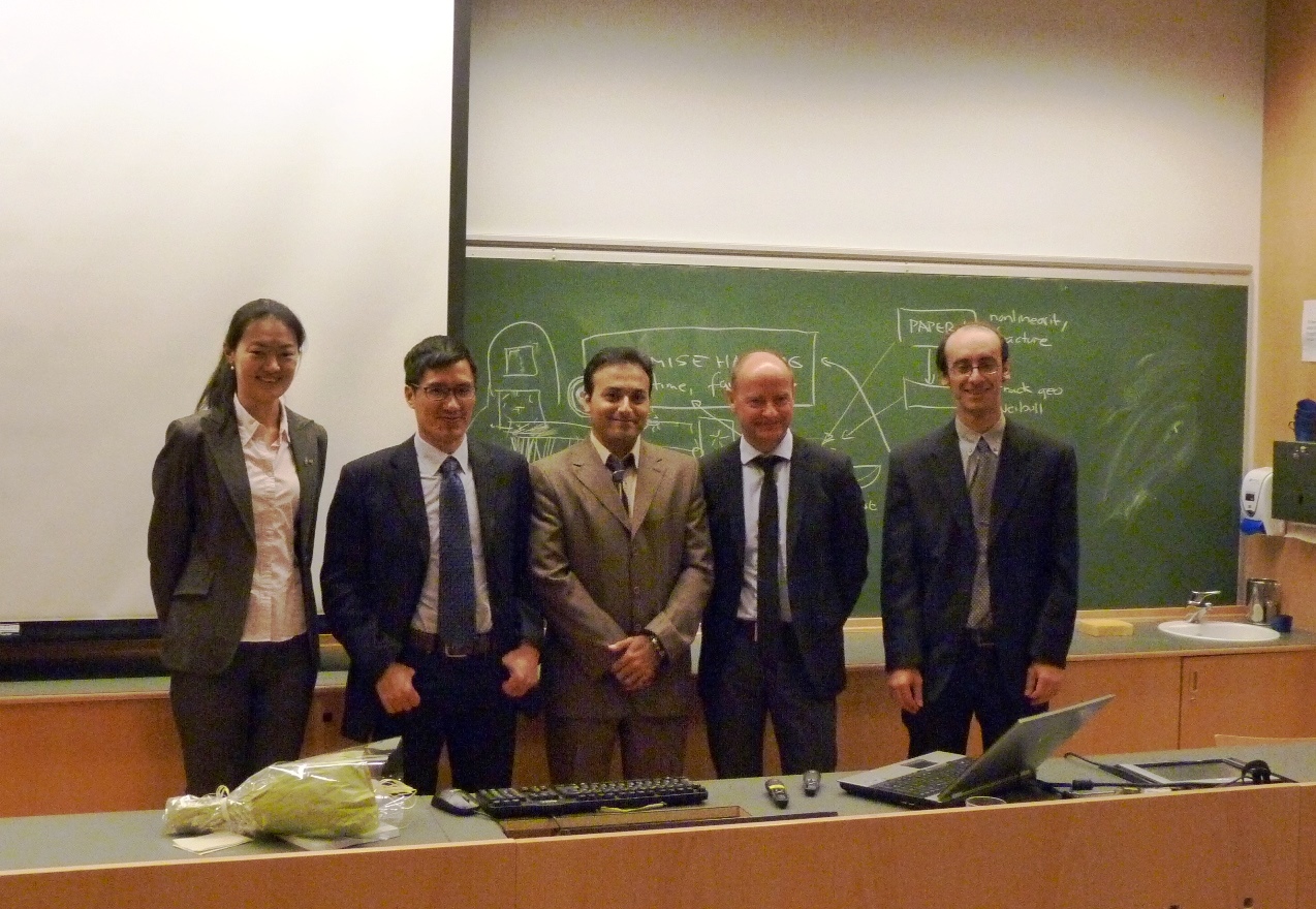Professors and students standing in front of a blackboard. Photo