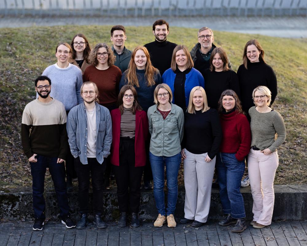 Employees standing together outside with grass behind them. Photo