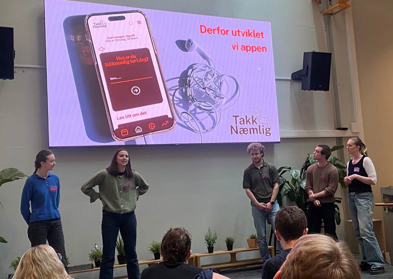 Five students on stage presenting their project