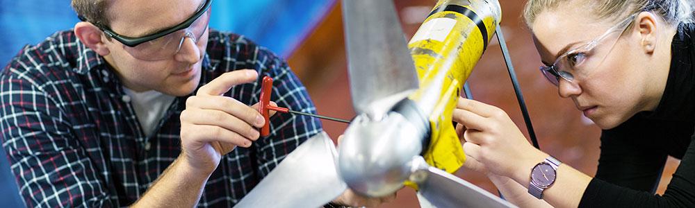 Two students are working on a small wind turbine. Photo: Geir Mogen/NTNU